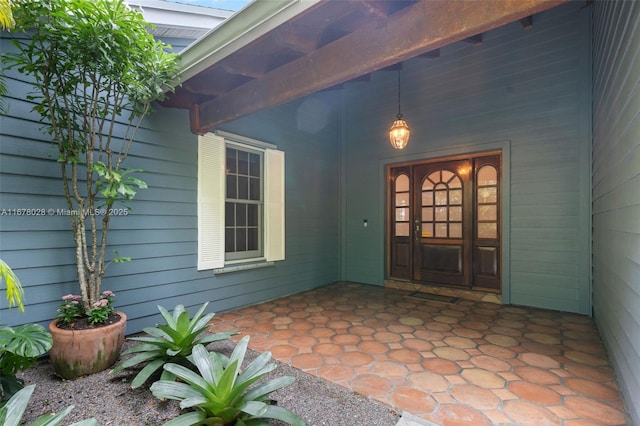 view of exterior entry with a patio