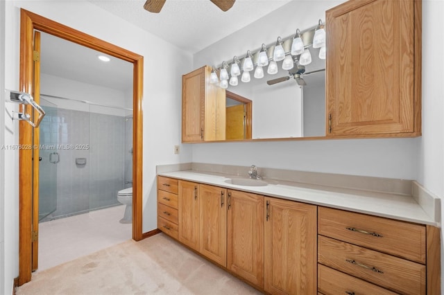 bathroom featuring vanity, toilet, ceiling fan, and walk in shower