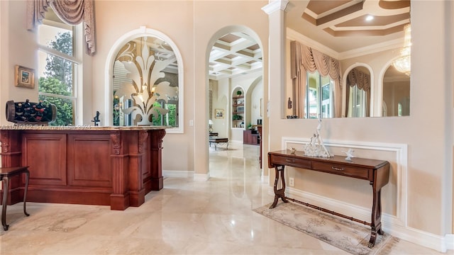 bar featuring beamed ceiling, coffered ceiling, ornate columns, and crown molding