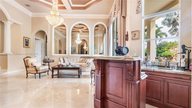 interior space with crown molding, a towering ceiling, sink, and pendant lighting