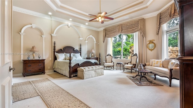 bedroom featuring ceiling fan, a raised ceiling, and multiple windows