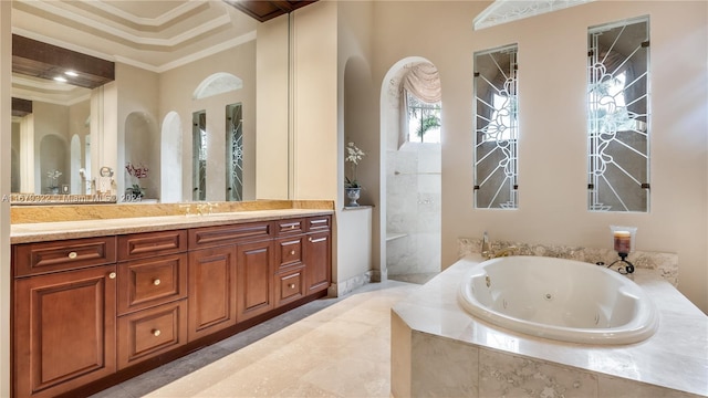 bathroom featuring vanity, crown molding, and a relaxing tiled tub