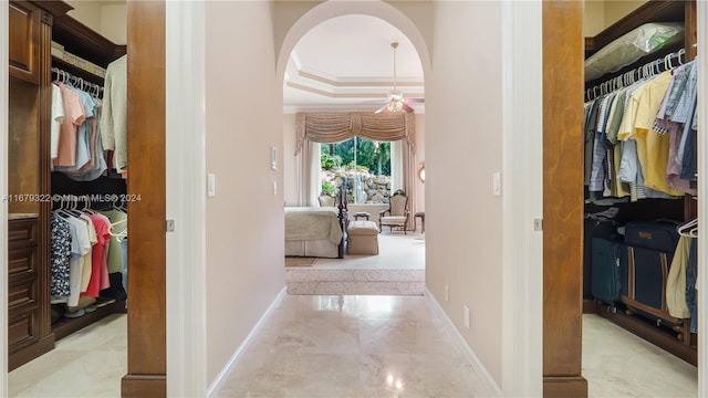 hallway featuring ornamental molding and a raised ceiling