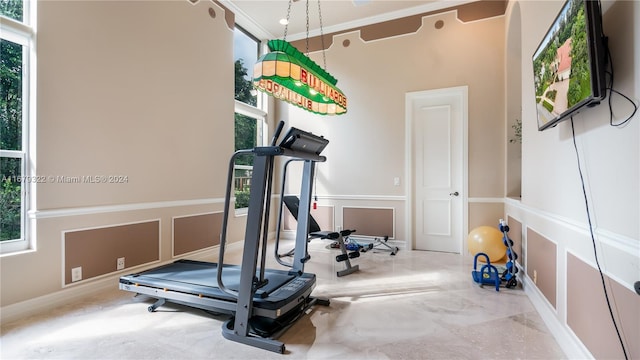 workout area with crown molding and concrete flooring