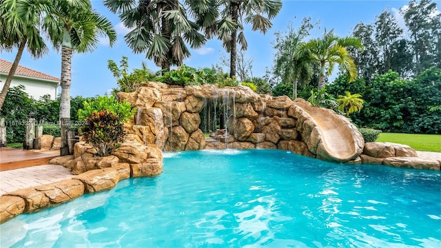 view of pool with a water slide and pool water feature