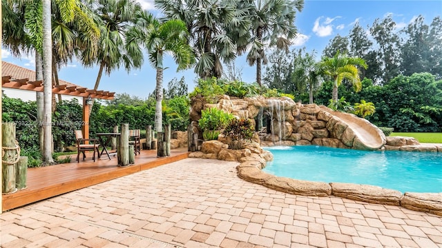 view of pool featuring a water slide, a wooden deck, and a pergola