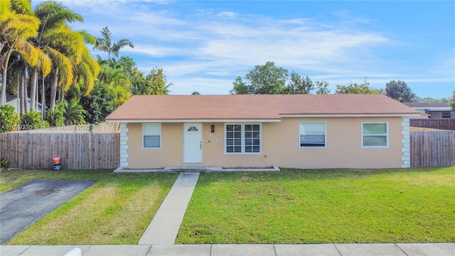 ranch-style house with stucco siding, a front lawn, and fence