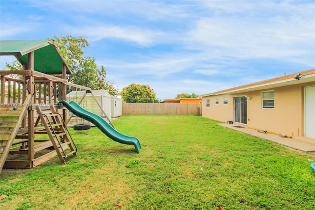 view of yard with a playground and a storage unit