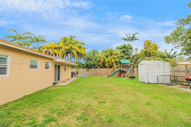 view of yard featuring a playground and a storage shed