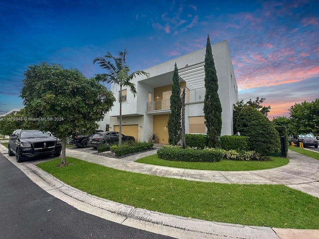 view of front of property with a balcony and a yard