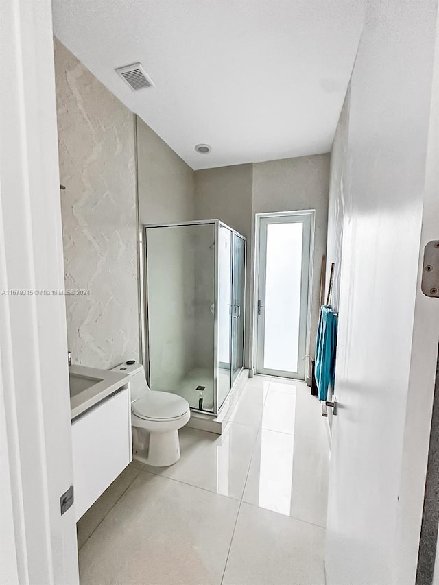 bathroom featuring vanity, an enclosed shower, toilet, and tile patterned floors