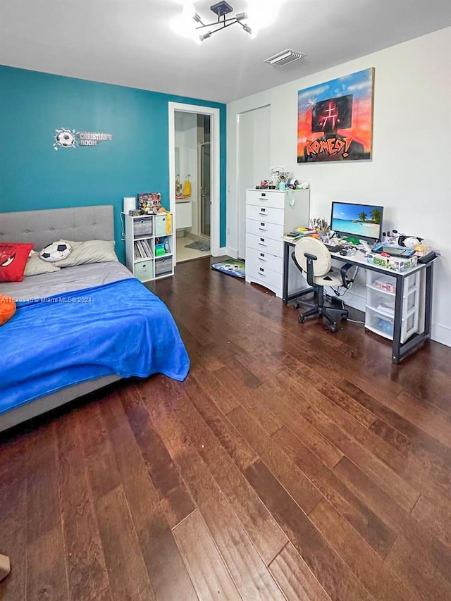 bedroom featuring ensuite bathroom and hardwood / wood-style flooring