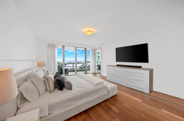 bedroom with access to outside, wood-type flooring, and floor to ceiling windows