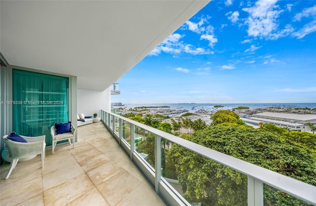 balcony featuring a water view and a view of the beach