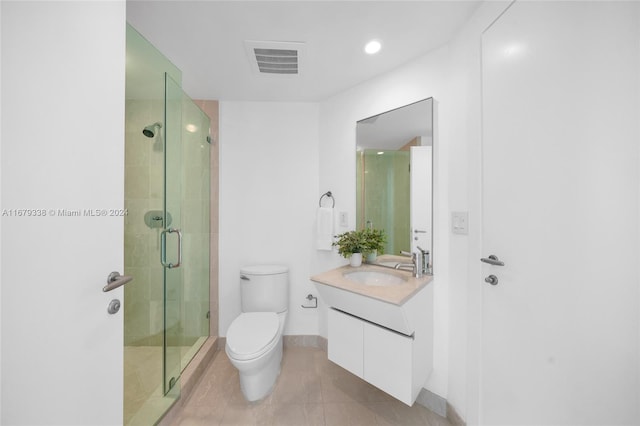 bathroom with vanity, an enclosed shower, toilet, and tile patterned floors