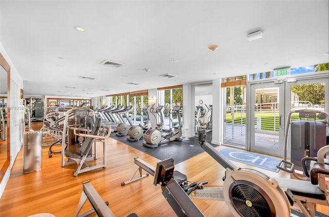 gym with french doors, light hardwood / wood-style flooring, and a wall of windows