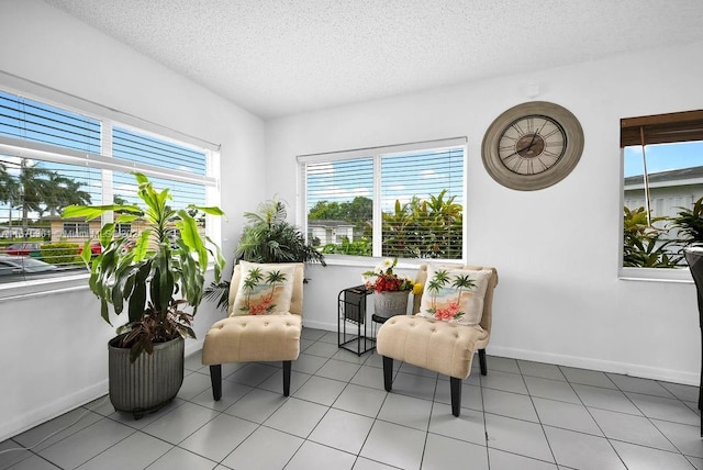 sitting room with a textured ceiling and light tile patterned floors