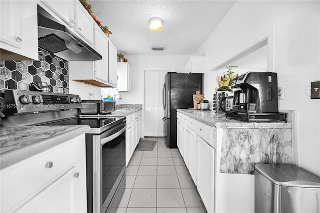 kitchen with white cabinets, black fridge, a textured ceiling, stainless steel range with electric stovetop, and sink