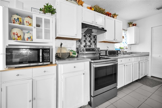 kitchen featuring sink, light tile patterned flooring, a textured ceiling, stainless steel appliances, and white cabinets