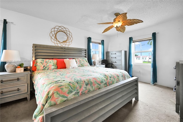 bedroom with ceiling fan, a textured ceiling, and carpet floors