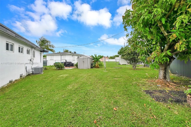 view of yard with central AC and a storage unit