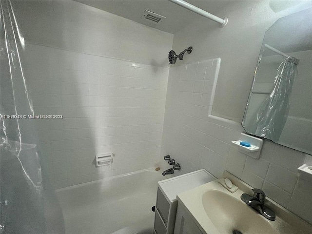 bathroom with shower / bath combo with shower curtain, vanity, and backsplash