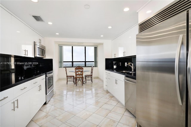 kitchen featuring stainless steel appliances, sink, and white cabinets