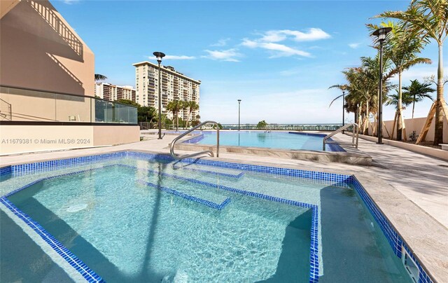 view of swimming pool featuring a patio area and a water view