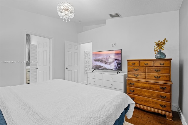 bedroom with dark hardwood / wood-style floors and a chandelier