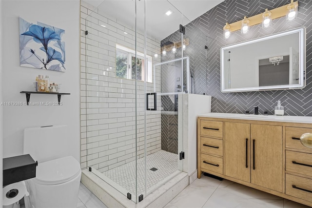 bathroom featuring tile patterned floors, vanity, toilet, and a shower with shower door