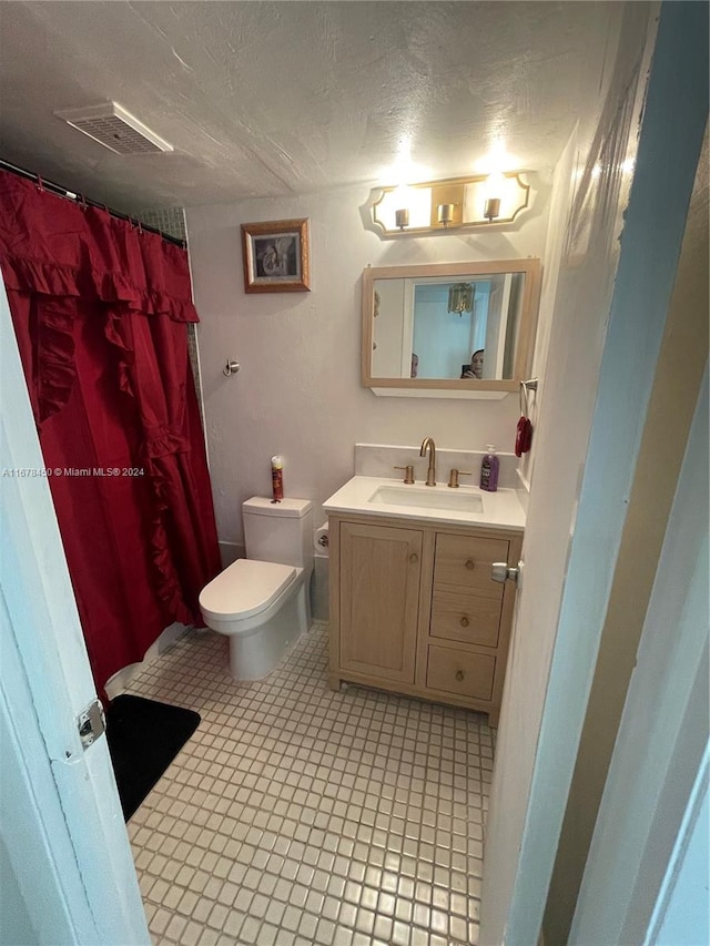 bathroom featuring vanity, toilet, and a textured ceiling