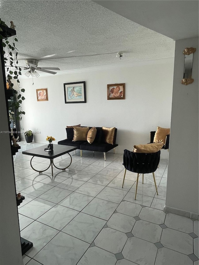 living room featuring ceiling fan and a textured ceiling