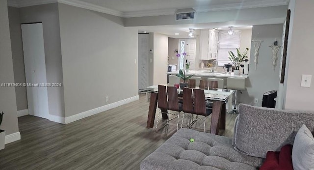 dining space featuring hardwood / wood-style floors, ceiling fan, crown molding, and sink