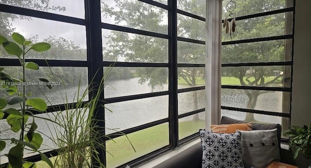 sunroom with plenty of natural light and a water view