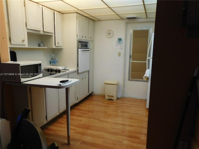 kitchen featuring light hardwood / wood-style flooring, white cabinetry, a paneled ceiling, and white appliances