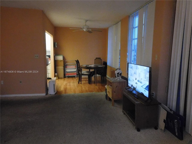 living area with carpet flooring and ceiling fan