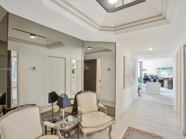 corridor with crown molding, light tile patterned flooring, and a tray ceiling