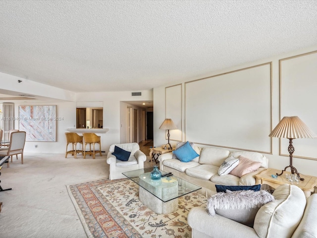 living room with a textured ceiling and light colored carpet