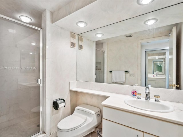 bathroom featuring vanity, toilet, and a shower with door