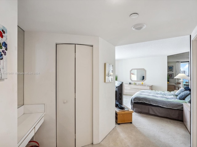 bedroom with light carpet and a closet