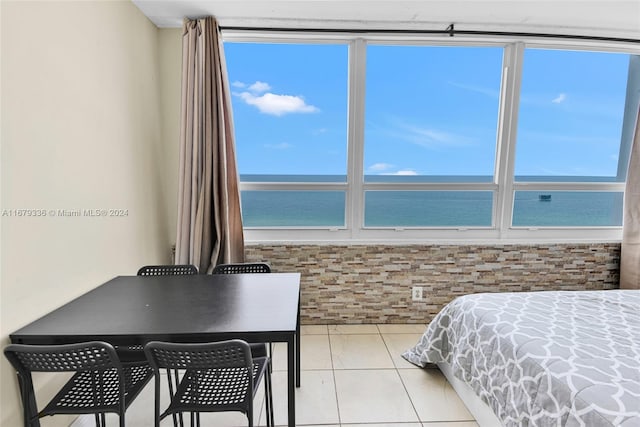 bedroom featuring light tile patterned flooring and a water view