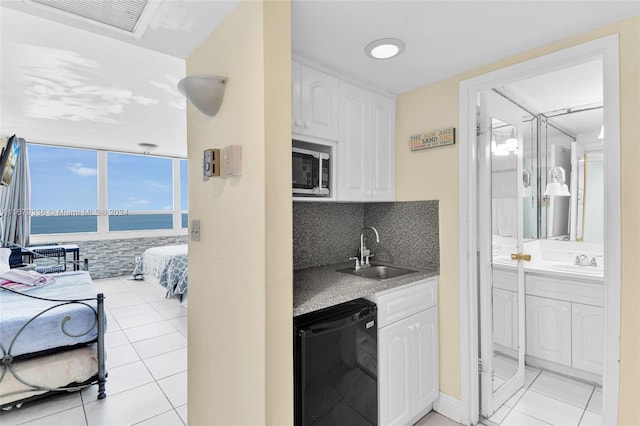 kitchen with a water view, black dishwasher, white cabinetry, and sink