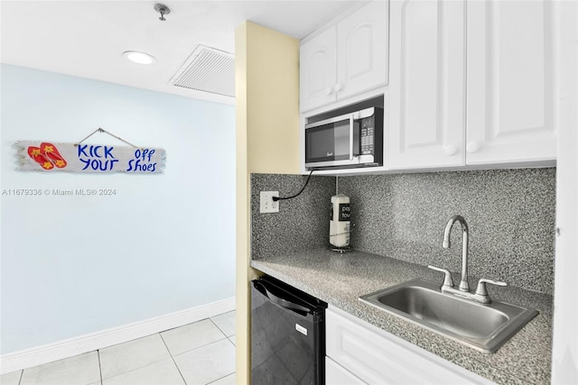 kitchen featuring dishwasher, sink, light tile patterned floors, white cabinetry, and tasteful backsplash