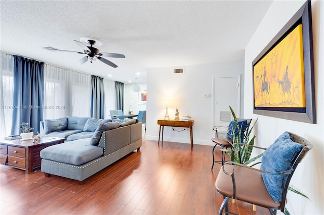 living room featuring a textured ceiling, ceiling fan, and dark hardwood / wood-style flooring