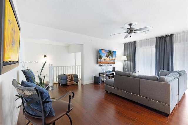 living room with dark hardwood / wood-style floors, a textured ceiling, and ceiling fan