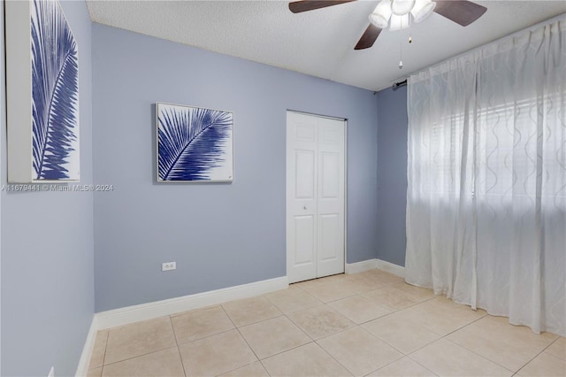 tiled spare room featuring ceiling fan and a textured ceiling