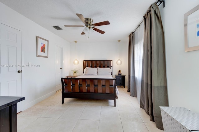 tiled bedroom featuring a textured ceiling and ceiling fan