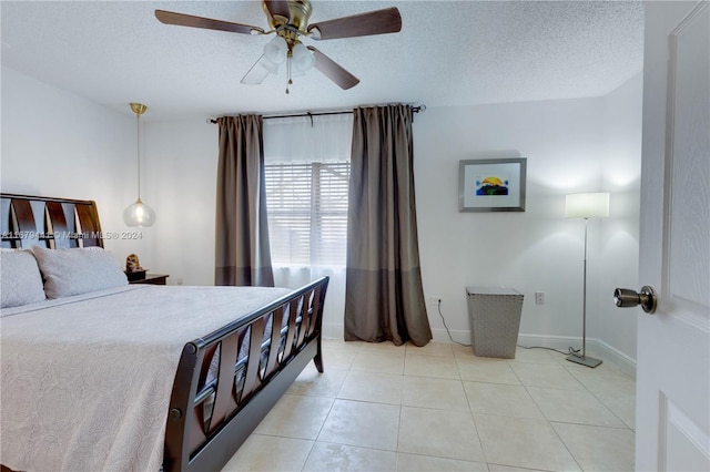 bedroom featuring a textured ceiling, light tile patterned floors, and ceiling fan