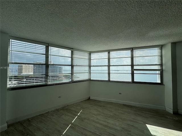 empty room featuring a textured ceiling and hardwood / wood-style floors