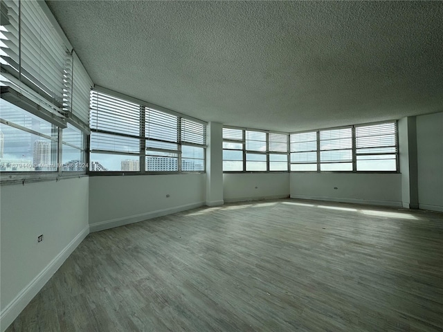 empty room with hardwood / wood-style floors and a textured ceiling